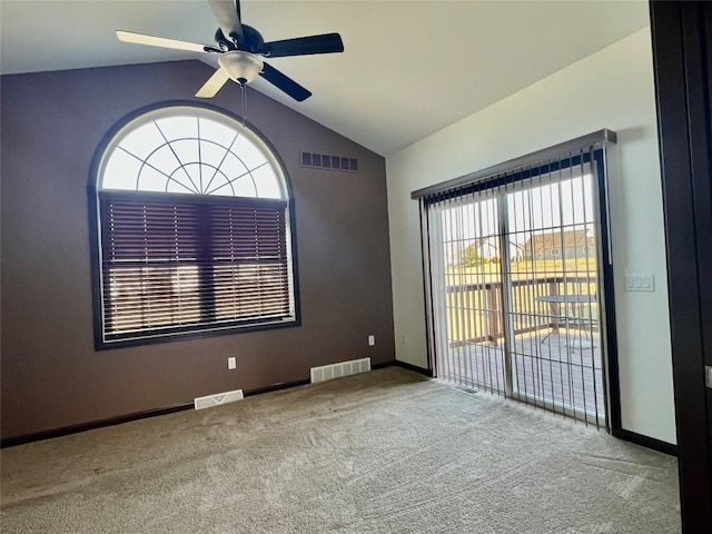 spare room with lofted ceiling, carpet flooring, and visible vents