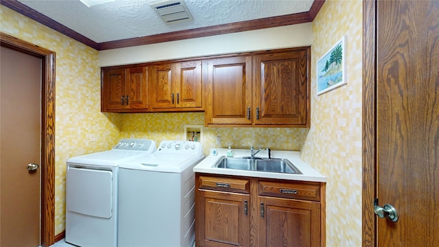 laundry area with sink, cabinets, a textured ceiling, washer and dryer, and ornamental molding