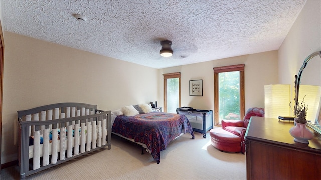 bedroom featuring ceiling fan, carpet floors, and a textured ceiling