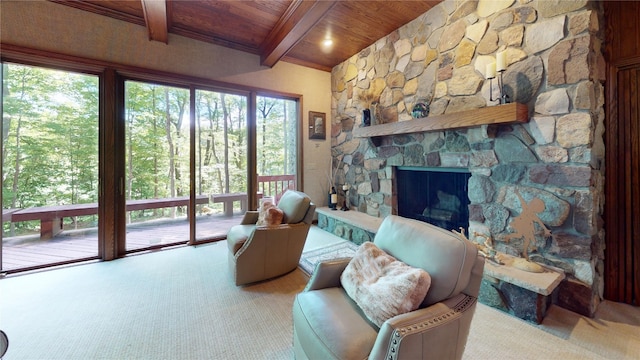 living room featuring beamed ceiling, a stone fireplace, and wooden ceiling