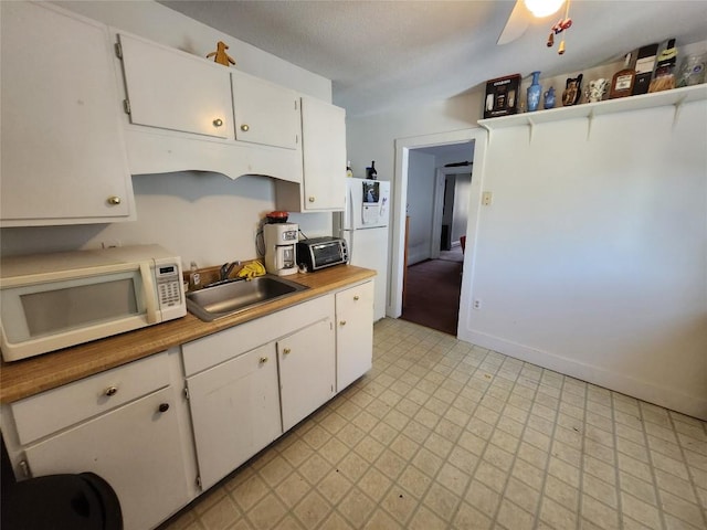 kitchen featuring white cabinetry, sink, and ceiling fan