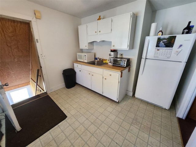 kitchen with white cabinets, white appliances, and sink