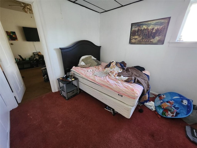 bedroom featuring carpet and a paneled ceiling