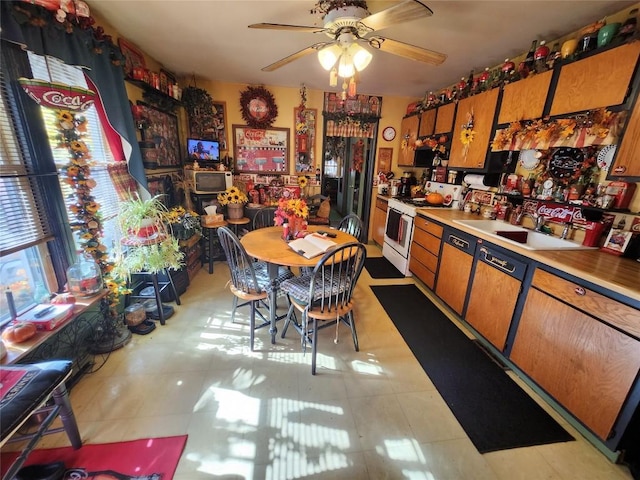 kitchen featuring ceiling fan, light tile patterned flooring, sink, and white stove