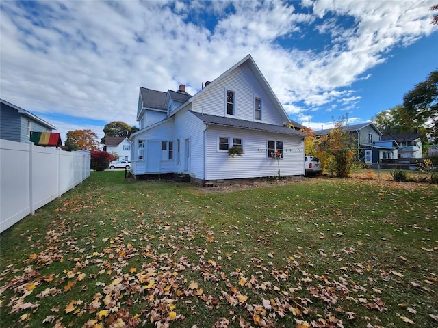 rear view of property with a lawn