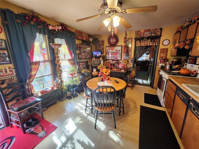 dining space featuring ceiling fan and sink