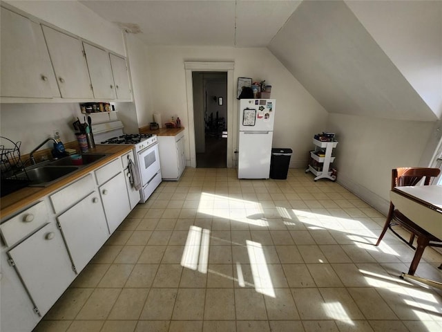 kitchen featuring sink, light tile patterned flooring, lofted ceiling, white appliances, and white cabinets