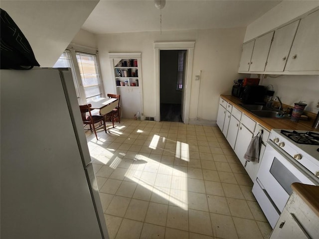 kitchen featuring white cabinets, white appliances, sink, and light tile patterned floors