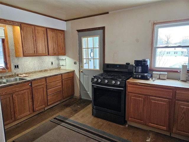 kitchen with sink, black range with gas stovetop, backsplash, crown molding, and dark wood-type flooring