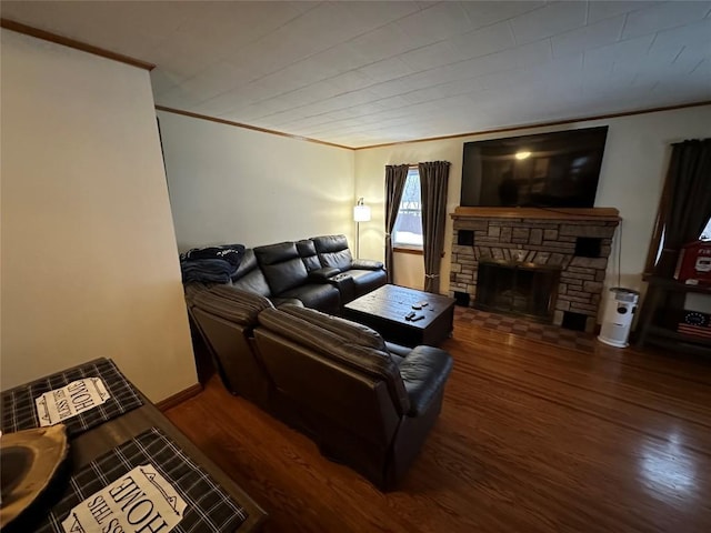 living room with dark hardwood / wood-style floors, a stone fireplace, and ornamental molding