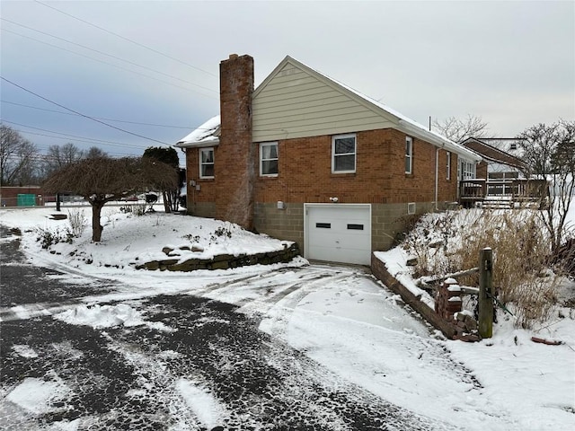 view of snow covered exterior featuring a garage