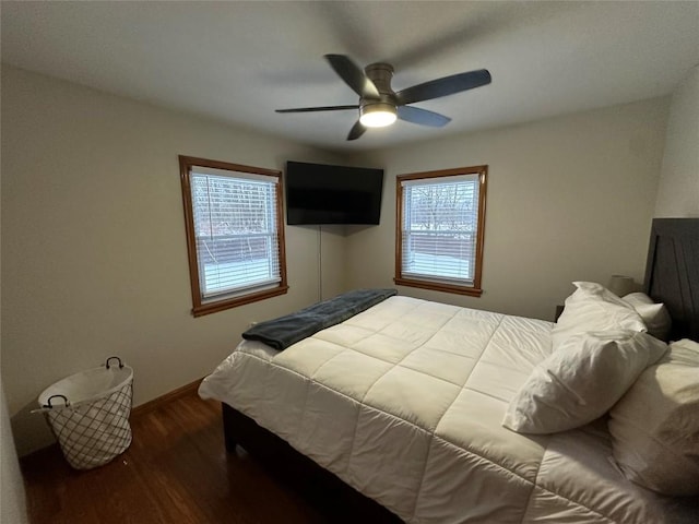 bedroom featuring multiple windows, ceiling fan, and dark hardwood / wood-style flooring