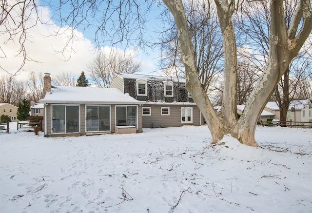 snow covered property featuring a sunroom