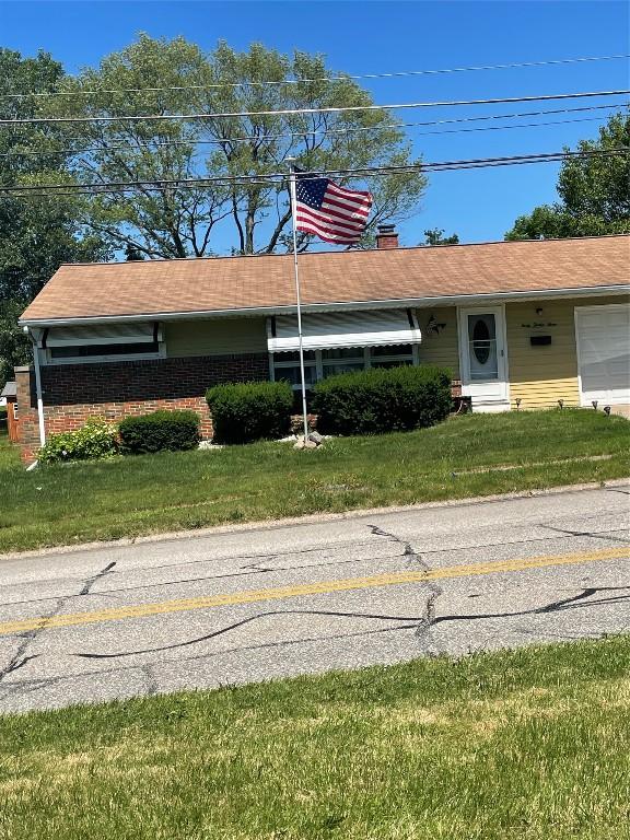 single story home featuring a front lawn