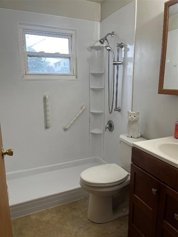 bathroom featuring vanity, toilet, and walk in shower