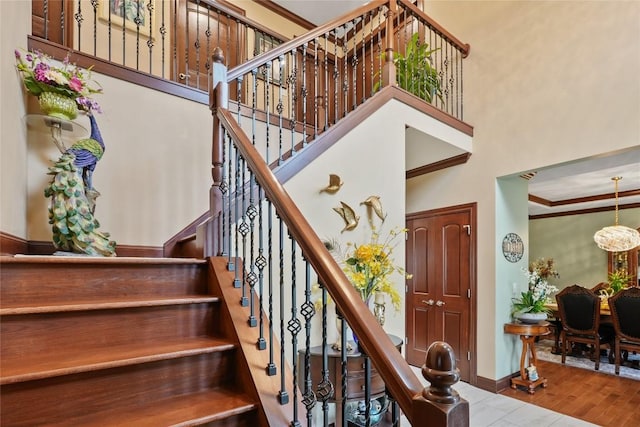 5640 Bear Run Cir, Fairview, PA 16415 - stairway featuring ornamental molding, baseboards, a towering ceiling, and wood finished floors