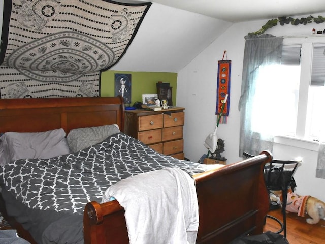 bedroom with hardwood / wood-style floors and vaulted ceiling