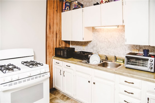212 Main St, Jamestown, PA 16134 - kitchen featuring white gas range, black microwave, light countertops, and white cabinetry