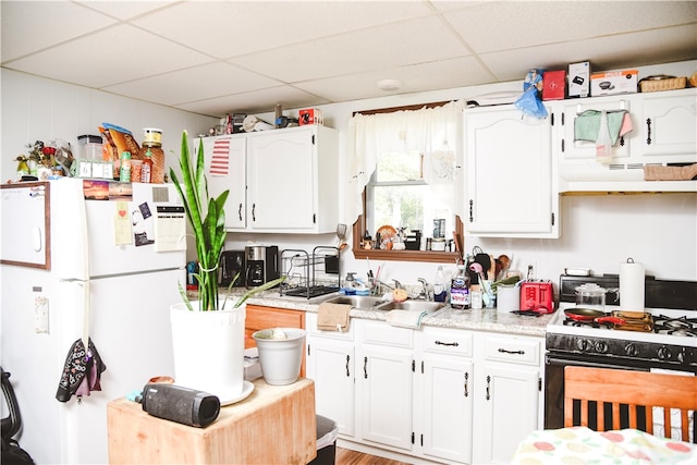 212 Main St, Jamestown, PA 16134 - kitchen featuring a drop ceiling, range with gas cooktop, under cabinet range hood, white cabinets, and light countertops