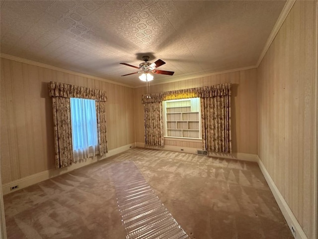 carpeted empty room with ceiling fan and crown molding