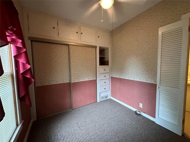 unfurnished bedroom featuring ceiling fan, a closet, and carpet