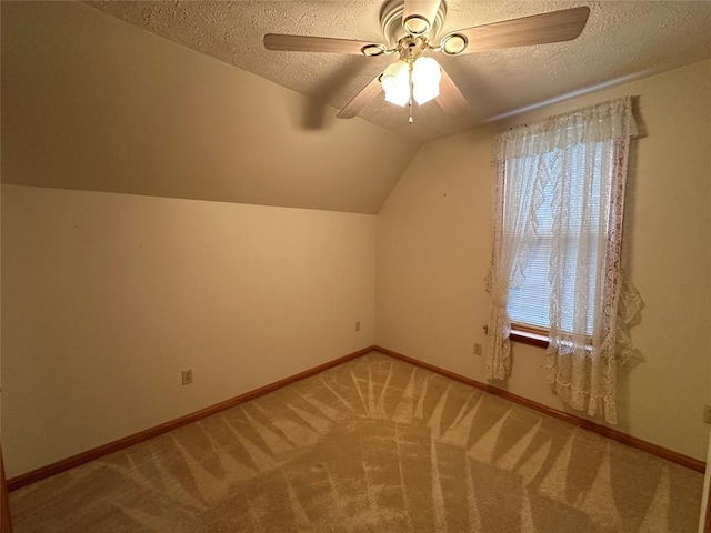 bonus room with carpet flooring, a textured ceiling, vaulted ceiling, and ceiling fan