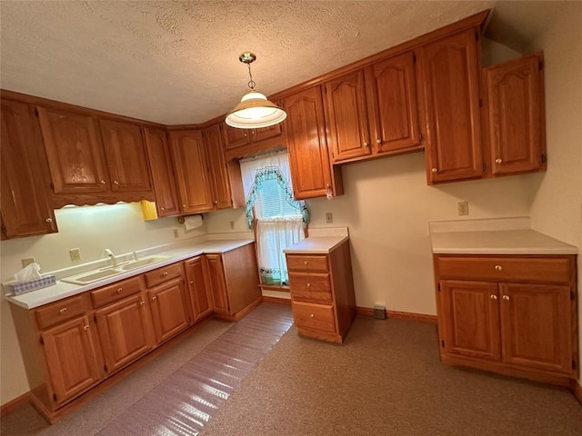 kitchen featuring sink, hanging light fixtures, and a textured ceiling