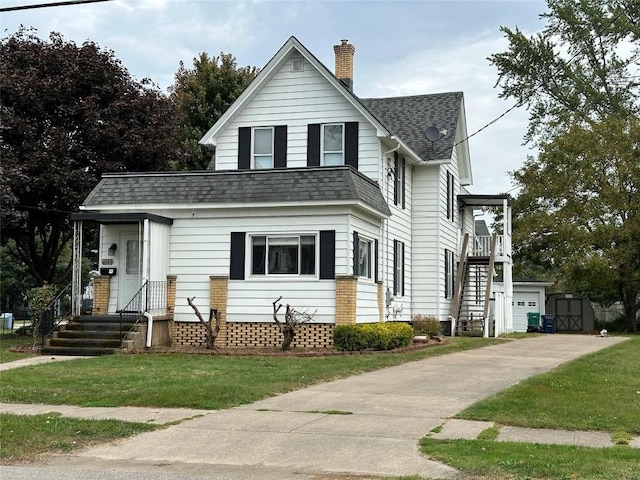 view of front facade with a front yard and a storage shed