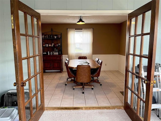 dining room with french doors and light tile patterned floors