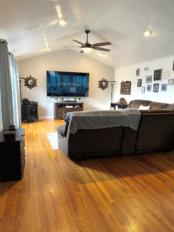 living room with ceiling fan, wood-type flooring, and lofted ceiling