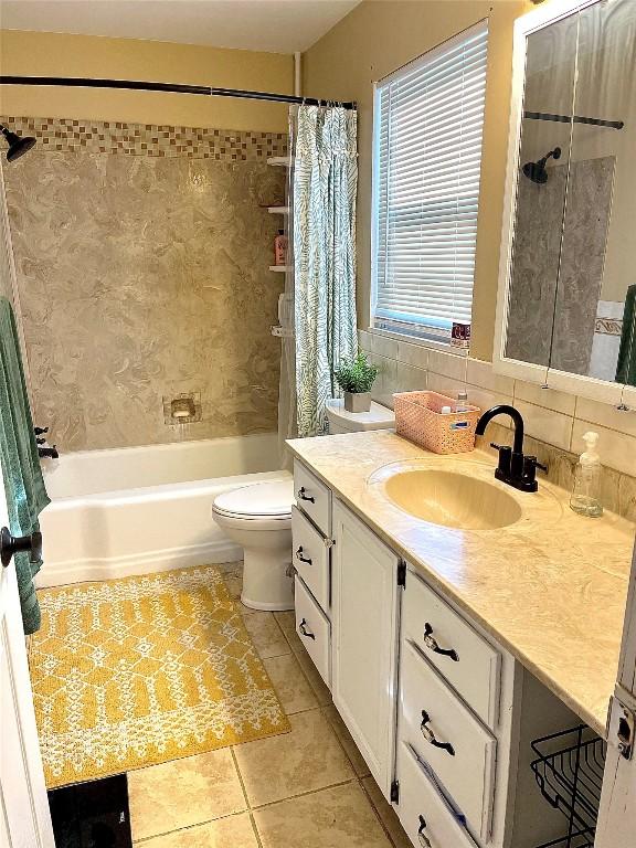 full bathroom featuring shower / bath combo, backsplash, tile patterned floors, toilet, and vanity