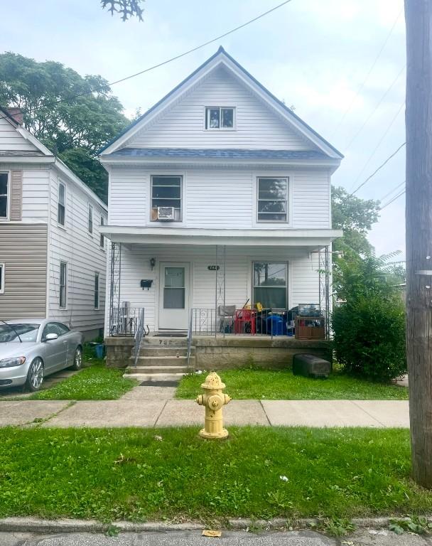 american foursquare style home featuring a porch and cooling unit