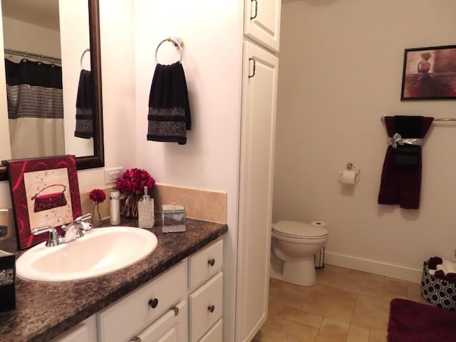 bathroom with tile patterned flooring, vanity, and toilet