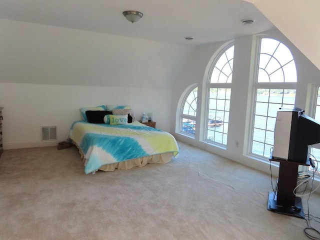 bedroom featuring light colored carpet and lofted ceiling