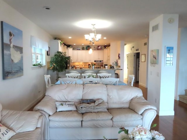 living room with a notable chandelier and dark wood-type flooring