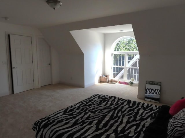 bedroom with lofted ceiling and light carpet