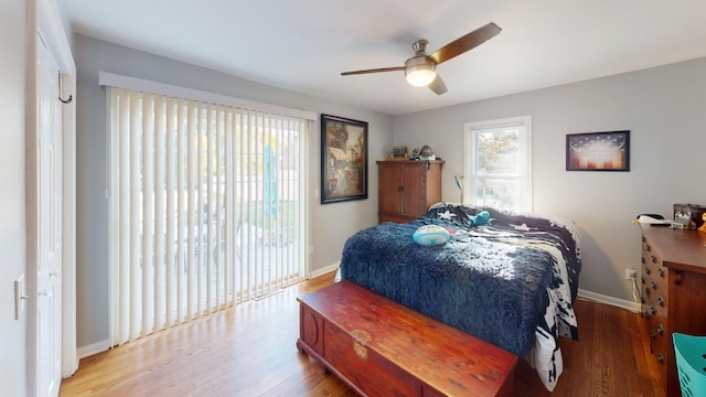 bedroom featuring access to outside, ceiling fan, a closet, and wood-type flooring