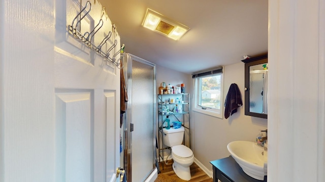 bathroom featuring toilet, a shower with door, vanity, and hardwood / wood-style flooring