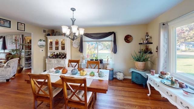 dining space featuring a notable chandelier and dark hardwood / wood-style floors