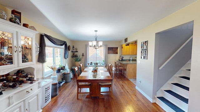 dining room featuring wood-type flooring and an inviting chandelier