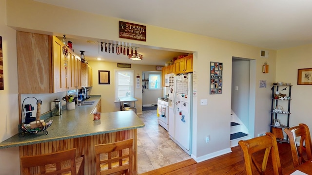 kitchen with kitchen peninsula, sink, and white appliances