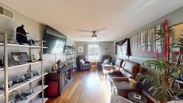 living room with ceiling fan and light hardwood / wood-style flooring