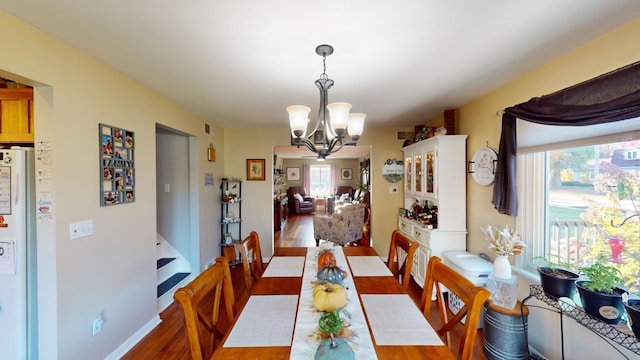 dining space featuring dark hardwood / wood-style floors and a chandelier