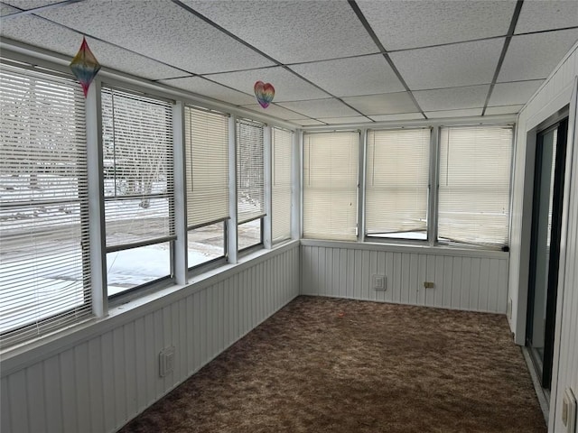 unfurnished sunroom featuring a drop ceiling and a wealth of natural light