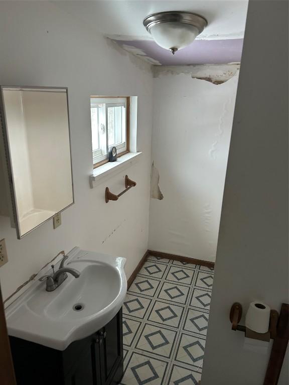 bathroom with vanity, baseboards, and tile patterned floors