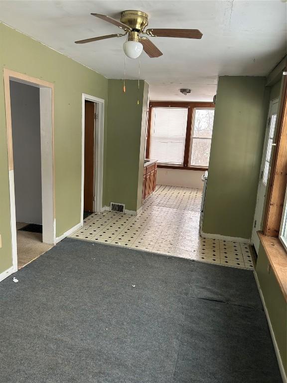 unfurnished room with light floors, visible vents, light carpet, and baseboards