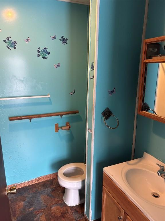 bathroom with toilet, stone finish floor, and vanity