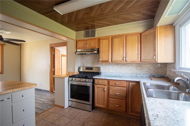 kitchen with decorative backsplash, a wealth of natural light, wood ceiling, gas range, and sink