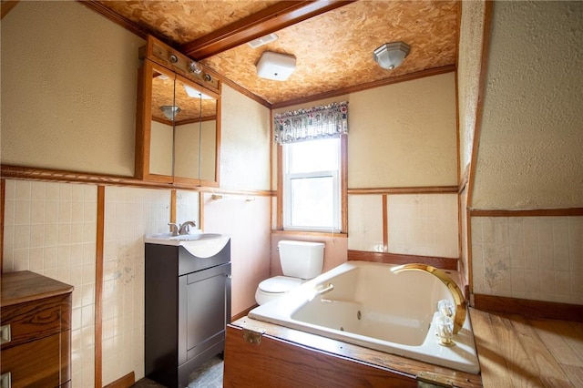 bathroom featuring vanity, toilet, ornamental molding, and a tub