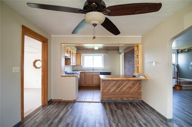 kitchen with kitchen peninsula, light brown cabinetry, tasteful backsplash, ceiling fan, and sink